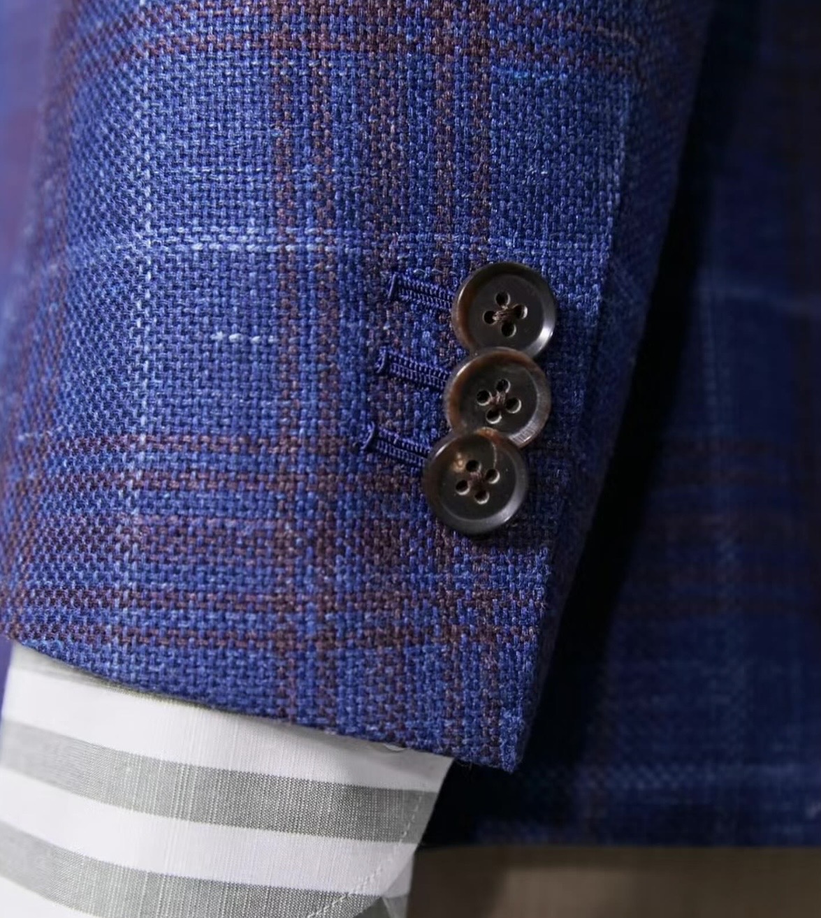 Close-up of hand-finished sleeve buttons on a bespoke jacket